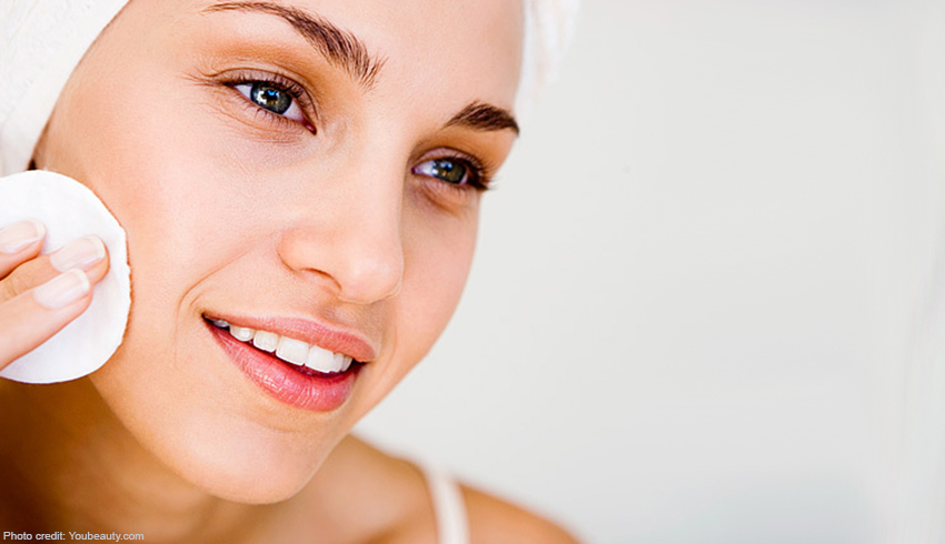 a woman using a cotton pad